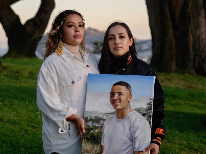 Sisters Ashley and Michelle Monterrosa holding a painting of their brother Sean, who was murdered by police.
